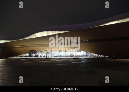Helsinki, Finlandia-30 novembre 2025: ingresso illuminato e facciata in legno moderna ondulata della Biblioteca Centrale di Helsinki Oodi di notte Foto Stock
