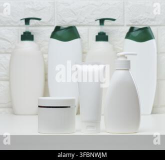 Vasetti e tubi in plastica bianca per cosmetici liquidi su fondo bianco. Branding, pubblicità Foto Stock