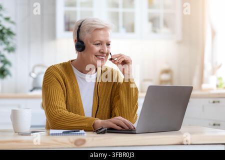 Felice vecchia donna che usa il laptop, che ha una videoconferenza Foto Stock