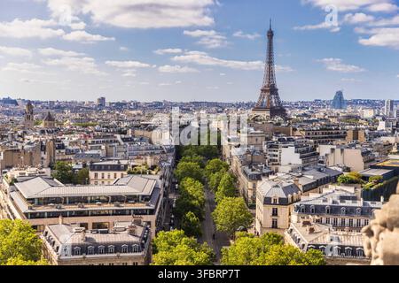 Vista aerea della Torre Eiffel e dei tetti della città haussmanniani dall'Arc de Triomphe a Parigi. Vista elevata ad angolo alto della città su viali alberati Foto Stock