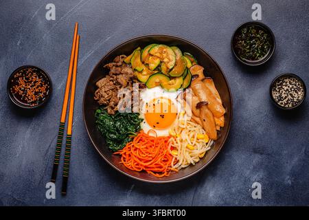 Bibimbap con verdure colorate, manzo e uovo in una ciotola Foto Stock