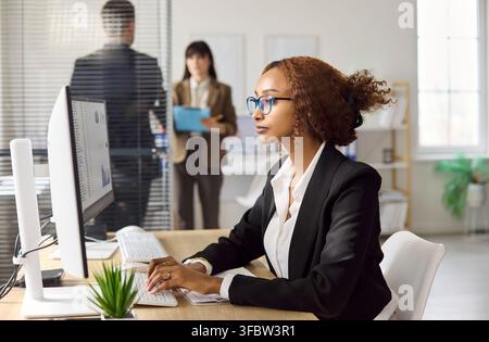 Contabile donna d'affari che lavora al computer con dati di foglio di calcolo in ufficio Foto Stock