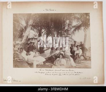 Re Kalakaua delle Hawaii, rilassato in un'amaca sotto le palme, circondato da persone di varie razze, in un ambiente rurale vicino a Honolulu, Hawaii, alla fine del XIX secolo, fotografato nel 1898-1899. Foto Stock