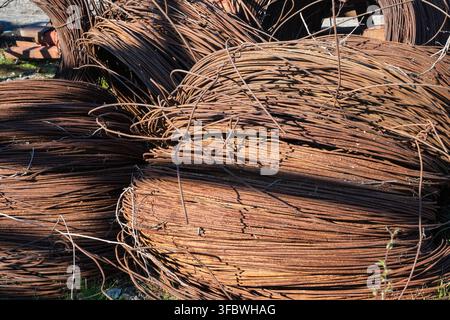 Cumuli aggrovigliati di vecchi cavi arrugginiti e rottami di metallo pronti per il riciclo. Foto Stock