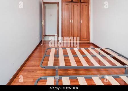 Camera da letto vuota con letti e pavimento in legno Foto Stock