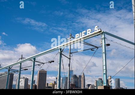 New York, USA - 15 ott. 2025: Pier 5 a Brooklyn, New York con lo skyline di Manhattan sullo sfondo. Foto Stock