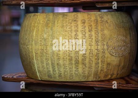 Sanremo, Italia - 30 maggio 2024: Ruote impilate di autentico parmigiano reggiano con timbri di origine DOP in mostra in un mercato agricolo Foto Stock
