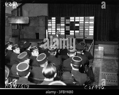 Un gruppo di persone in uniforme che frequentano un corso di lingua inglese alla prefettura di polizia, con una lavagna luminosa, in una stampa del 1932, un'agenzia di fotografia di stampa francese. Foto Stock
