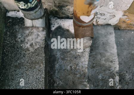 Acqua che scorre lungo i gradini di cemento dai tubi in una giornata di pioggia in città Foto Stock