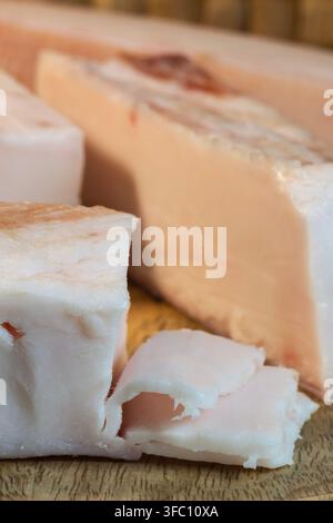 Un primo piano mostra spessi pezzi di grasso di maiale crudo e speziato o salo ricoperti di pepe nero, sale e paprika. Foto Stock
