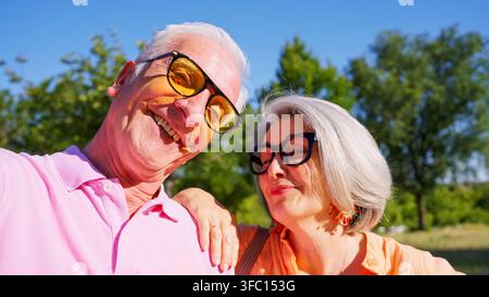 Coppia di anziani felici che sorride per un selfie in una giornata di sole Foto Stock