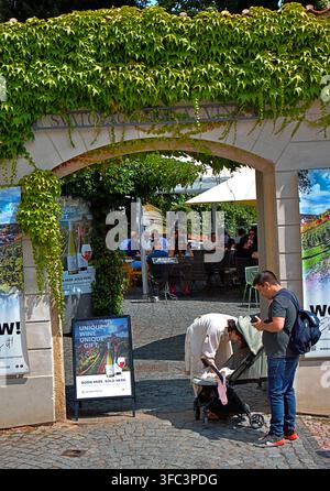 Praga, Repubblica Ceca – 28 luglio 2026: I visitatori si rilassano all'ingresso della terrazza della vigna vicino al Castello di Praga, circondati da edera verde. Foto Stock