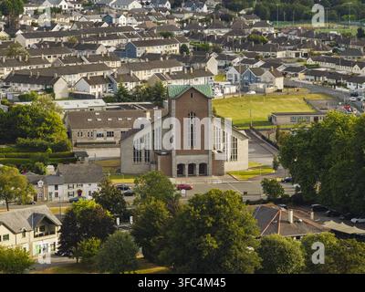Vista aerea della Chiesa della Resurrezione con il suo caratteristico tetto di rame verde e la facciata in mattoni, circondata da tetti residenziali e alberi rigogliosi Foto Stock