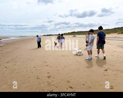 Persone che camminano sulla spiaggia con cani a Mablethorpe, Lincolnshire, Regno Unito Foto Stock