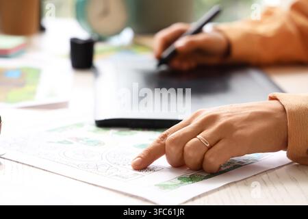 Progettazione digitale e lavoro creativo, persona che utilizza una tavoletta grafica e uno stilo per disegni architettonici o pianificazione del paesaggio Foto Stock