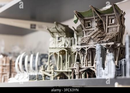 Una collezione di case in miniatura, che mostra vari stili architettonici e design di interni, esposti in un negozio o in una mostra. Foto Stock