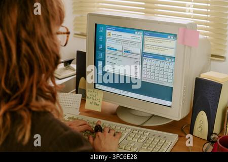 Donna che digita su una tastiera di computer retrò in un ufficio vintage Foto Stock