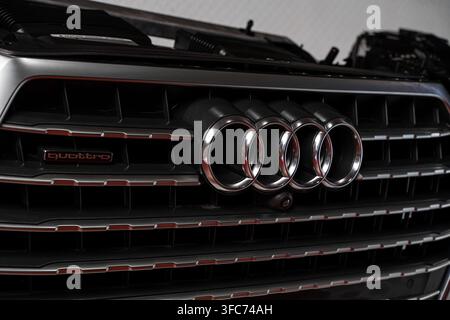 Prima di una griglia anteriore Audi con l'emblema a quattro anelli e il marchio quattro su un componente del paraurti smontato. Foto Stock