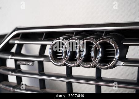 Prima di una griglia anteriore Audi con l'emblema a quattro anelli e il marchio quattro su un componente del paraurti smontato. Foto Stock