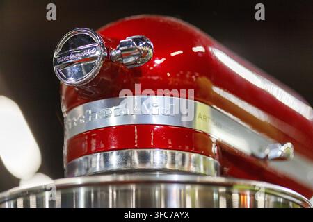 Un primo piano, vista dall basso, di una frullatrice da banco KitchenAid Artisan rossa lucida, con il focus sulla sua testa, fascia e ciotola in acciaio inossidabile Foto Stock