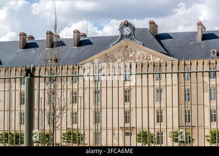 La Caserma Thiry, una caserma costruita tra il 1764 e il 1769 sotto l'architetto Richard Mique per Luigi XV, presenta la sua facciata principale classica con un orologio e un bassorilievo scolpito sul frontone in Rue Sainte-Catherine a Nancy, Grand Est, Francia. Una recinzione in ferro battuto separa l'edificio ancora utilizzato a scopo militare dalla strada. Dal 2024, le sue ali laterali ospitano anche uffici amministrativi civili. Foto Stock