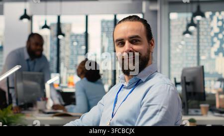Primo piano di Happy trader sul luogo di lavoro di un'azienda di produzione che analizza i dati di mercato ed esegue operazioni utilizzando l'interfaccia software di trading su PC. Joyous stockbroker al lavoro che controlla i prezzi delle azioni Foto Stock