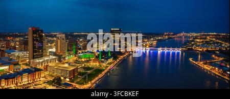 Toledo, Stati Uniti - 17 aprile 2026: Veduta aerea dello skyline della città di notte con il fiume Maumee, ponti illuminati e un arco urbano moderno Foto Stock