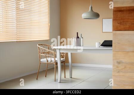 Interno moderno di ufficio domestico o sala da pranzo, lavoro da remoto e design minimalista, spazio vuoto con luce naturale Foto Stock