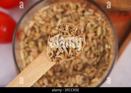 Semi di finocchio in un cucchiaio di legno sul tavolo Foto Stock
