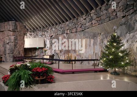 Helsinki, Finlandia-30 nov. 2025: altare principale decorato con un albero di Natale e fiori nella chiesa Temppeliaukio (chiesa di pietra), Helsinki, Finlandia Foto Stock