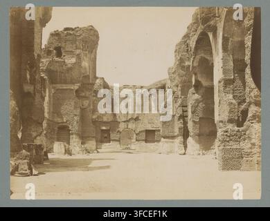 Vista delle Terme di Caracalla, Terme di Caracalla, fotografia, numero: '4038 A.', Roma, 1851 - c. 1900, fotografo, cartone, carta, stampa all'albumina, altezza 255 mm x larghezza 355 mm, rovina di un edificio, architettura, Terme di Caracalla. Una fotografia seppia che mostra un grande cortile aperto circondato da alte mura di pietra consumate e rovine con superfici irregolari e arcate arrotondate. Le facce rocciose verticali presentano texture visibili, cavità ed erosione stratificata, con alcune forme ad arco e nicchie incise. Il terreno è piatto e sabbioso, con alcuni blocchi di pietra e frammenti sparsi Foto Stock