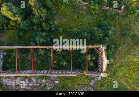 Veduta aerea di una struttura industriale in rovina con travi metalliche esposte e vegetazione verde rigogliosa che cresce all'interno delle pareti a Danzica, Pomerania Foto Stock
