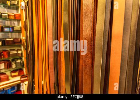 Close up di diversi colori e modelli di cinture in pelle in vendita in un bazar di mercato aperto a Delhi. La cintura è una fascia o una cinghia flessibile, tipicamente realizzata in Foto Stock