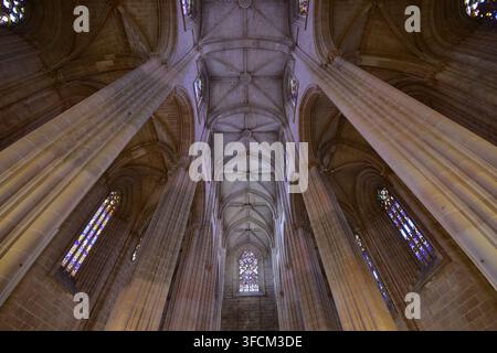 Vista ad angolo basso verso l'alto della navata a volta che si innalza all'interno del Monastero di Batalha in Portogallo. Foto Stock