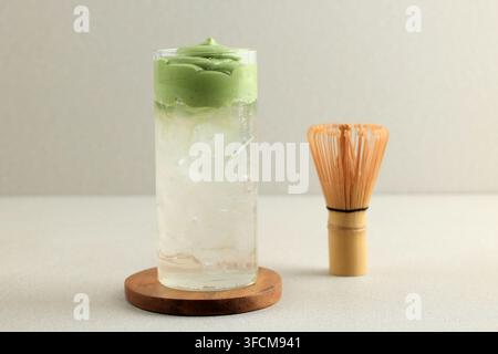 Bevanda ghiacciata Cloud Matcha con cocco, Dalgona cremosa al Matcha con acqua di cocco ghiacciata isolata su sfondo color crema Foto Stock