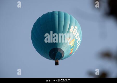 Vibrante mongolfiera turchese che vola in alto contro un cielo sereno, ideale per concetti di viaggio, avventura e libertà. Foto Stock