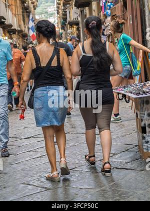 Due donne che camminano lungo un vicolo lastricato, Napoli, Italia. Foto Stock