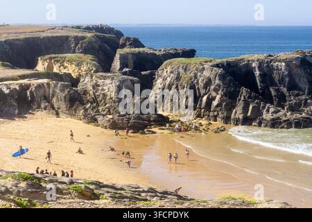 Vacanzieri su una piccola baia sabbiosa circondata da scogliere frastagliate sulla Cote Sauvage, penisola di Quiberon, Bretagna, Francia. Foto Stock