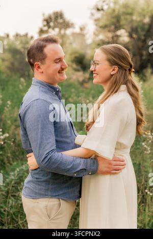 Giovane coppia felice che si abbraccia e si sorride l'un l'altro Foto Stock