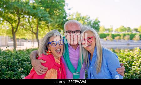 Amici anziani che ridono e si abbracciano nel parco Foto Stock