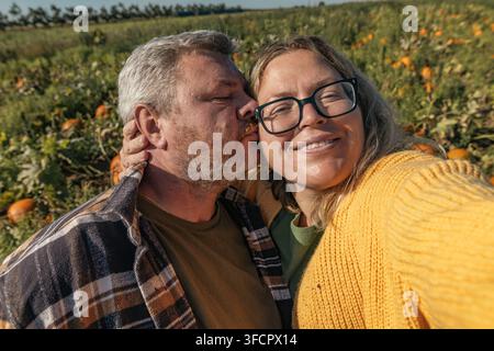 Famiglia che gode di una giornata autunnale in un campo di zucche Foto Stock