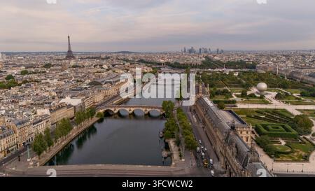 Vista elevata sul fiume Senna che mostra il Pont Royal, gli edifici del Louvre, il Giardino delle Tuilerie e la Torre Eiffel nella lontana linea del cielo di Parigi. Foto Stock