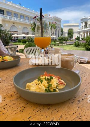 Uova strapazzate, caffè e succo d'arancia serviti in un ristorante all'aperto di un resort Foto Stock