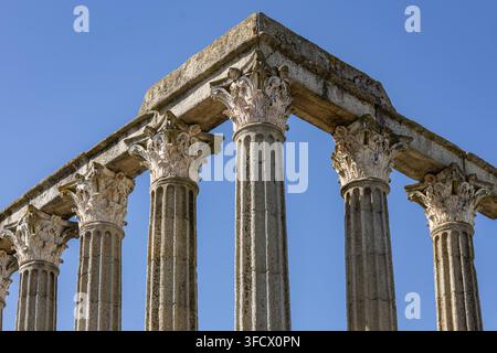 Vista del Tempio Romano di Évora con colonne corinzie erose sullo sfondo di un cielo blu limpido, Évora, Distrito de Évora, Portogallo. Foto Stock