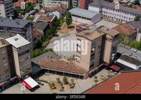 Pristina, Kosovo - 19 giugno 2025: Vista di edifici residenziali e di un cortile centrale con alberi e superfici lastricate nel centro città di Pristi Foto Stock