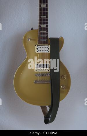Chitarra elettrica Goldtop con pickup Humbucker in piedi su un supporto per chitarra. Foto Stock