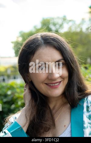 Prima piano del volto di una bella donna bruna di mezza età che guarda verso l'obiettivo. Foto Stock