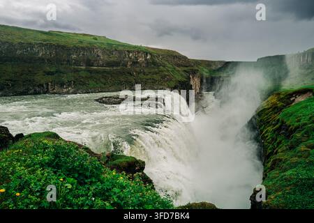 La cascata di Gullfoss che si getta in una gola frastagliata sotto cieli tempestosi nel sud-ovest dell'Islanda. Foto Stock