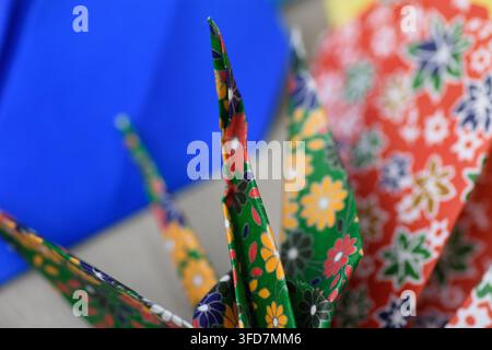 Un'immagine tranquilla in primo piano con gru origami giapponesi tradizionali meticolosamente realizzate, disposte in una composizione a profondità di campo poco profonda. La vibra Foto Stock