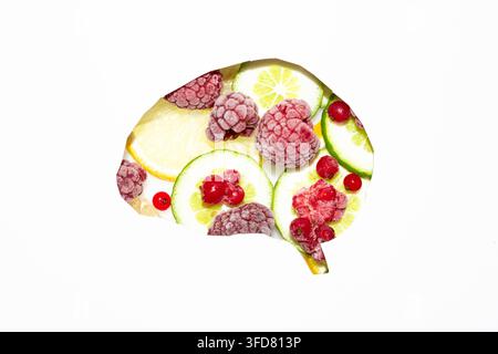 Concetto creativo di cervello sano formato da frutta fresca, bacche, fette di agrumi e noci su uno sfondo bianco pulito con spazio per il testo. Foto Stock